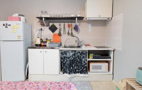 a small kitchen with a sink and a refrigerator at Mungyeong YeoU in Mungyeong
