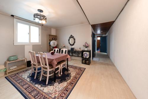 a dining room with a table and chairs on a rug at Mungyeong YeoU in Mungyeong