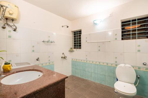 a bathroom with a sink and a toilet at Independent Villa with private pool in Siolim Goa in Oxel