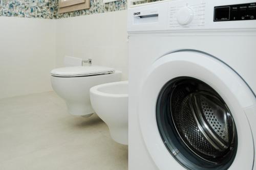 a washing machine and a toilet in a bathroom at Le Stanze di Lucia vicino Ospedale Cardinale Panico a Tricase in Tricase