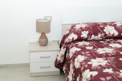 a bedroom with a bed and a lamp on a nightstand at Le Stanze di Lucia vicino Ospedale Cardinale Panico a Tricase in Tricase