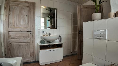 a white bathroom with a sink and a mirror at Auszeit & Natur - ländliche Fachwerkhaushälfte in Nümbrecht