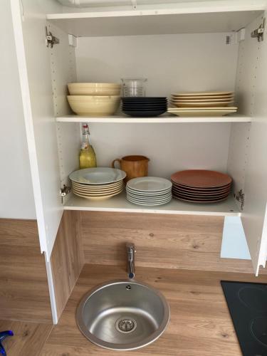 a sink in a kitchen with plates and bowls at Vacances à la mer in Cagnes-sur-Mer