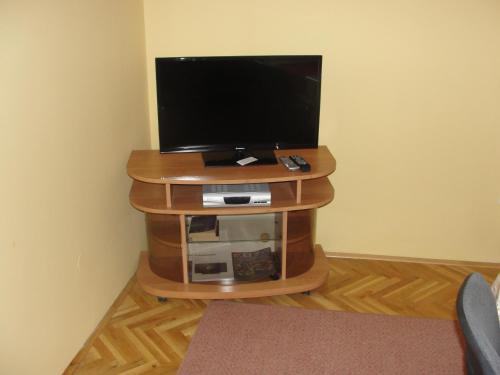 TV de pantalla plana en un soporte de madera en una habitación en Apartments Lalic, en Vodice