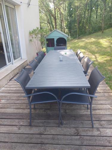une table de pique-nique avec des chaises sur une terrasse en bois dans l'établissement Notre petit coin de paradis, à Saint-Germain-du-Bel-Air