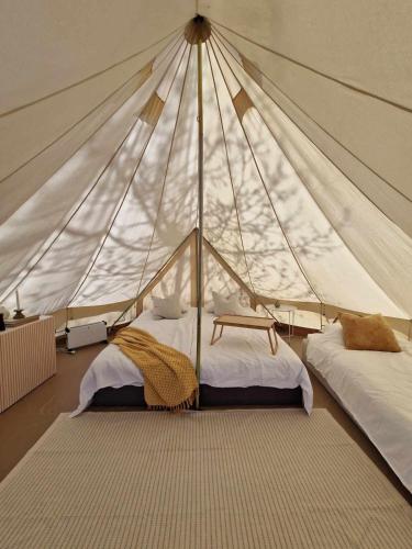 a bedroom with two beds in a tent at Bergs Slussar Glamping in Vreta Kloster