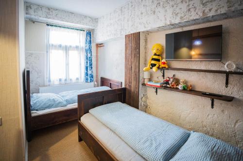 a small bedroom with two beds and a tv at Farma Kozí dvor Rohozná in Brezno