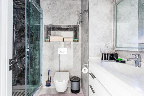 une salle de bain avec toilettes, baignoire et lavabo dans l'établissement Silk Road Skyline Tashkent City, à Tachkent