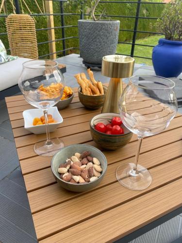 a wooden table with wine glasses and food on it at Chambre des Tours in Mont-Saint-Éloi