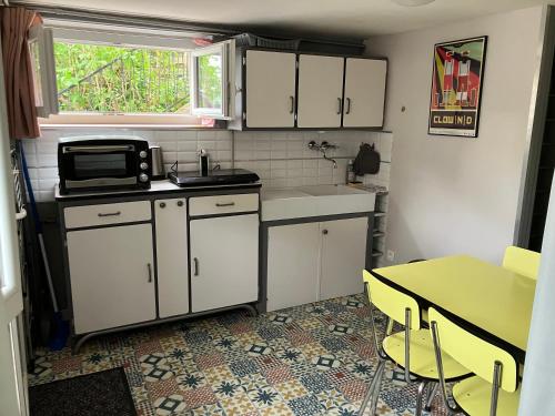 une petite cuisine avec une table et un micro-ondes dans l'établissement Au calme, proche gare, à Brive-la-Gaillarde