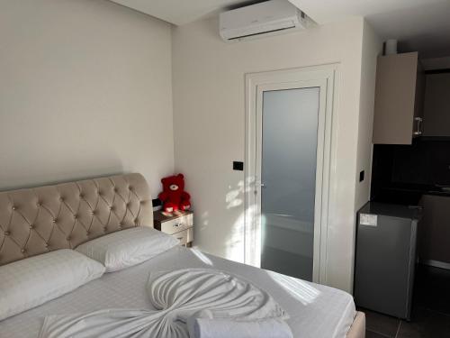 a bedroom with a bed and a door to a kitchen at Villa Fjori Ksamil in Ksamil