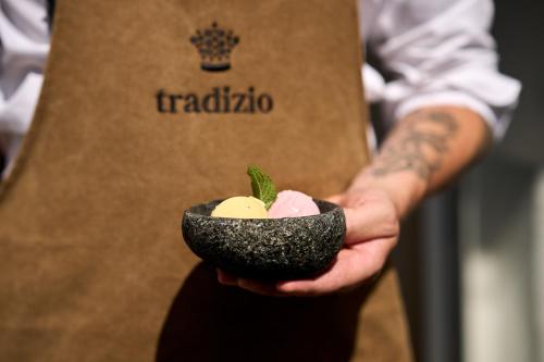 a man is holding a bowl of ice cream at Hotel Tradizio in Mittelberg
