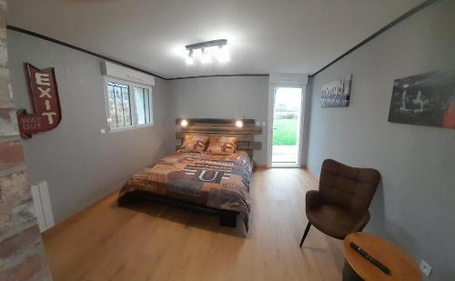 a bedroom with a bed and a chair in it at Ongi Etorri Chez les Ch'tis in Saint-Jean-le-Vieux