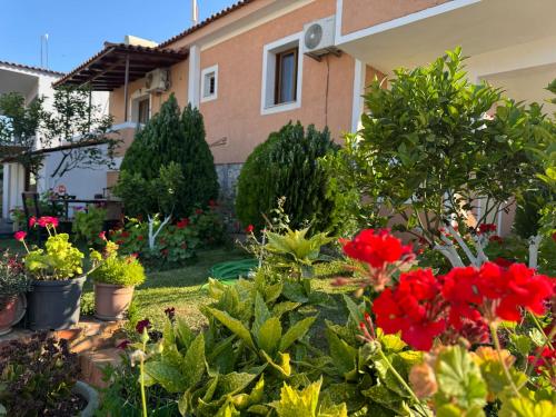 a garden with flowers and plants in front of a house at Villa Fjori Ksamil in Ksamil