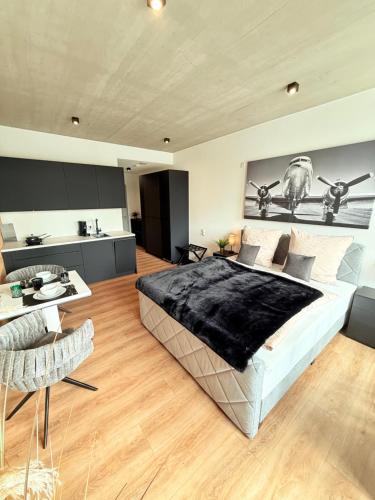 a bedroom with a large bed and a kitchen at MIWO Friedrichshafen in FDH