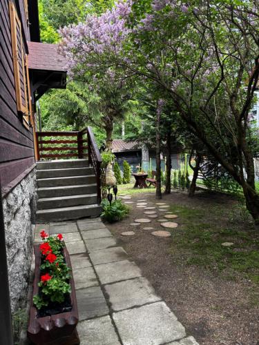 a garden with flowers in a flower bed next to a house at Biały Jar Ski & Bike Apartamenty w Karpaczu przy wyciągu z widokiem in Karpacz