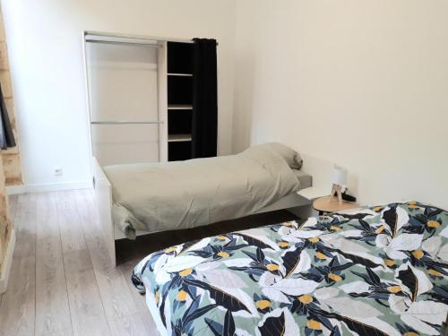 une chambre avec deux lits et un placard dans l'établissement Appartement de charme proche citadelle, à Blaye