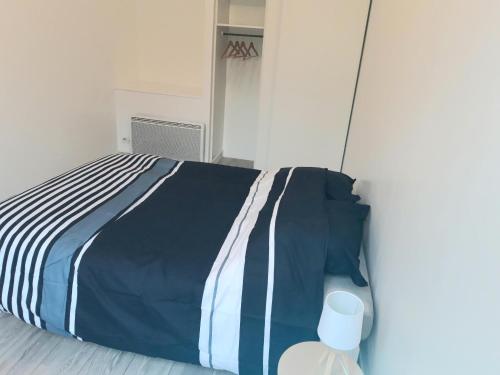 - un lit avec une couette bleue et blanche dans l'établissement Appartement de charme proche citadelle, à Blaye
