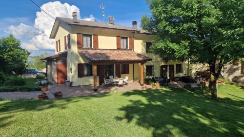a large yellow house with a yard with a tree at La Quagnola Casa vacanze in Polinago