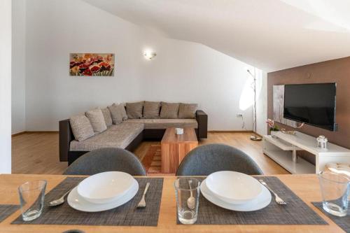 a living room with a table and a couch at Apartments Villa Mirela in Petrcane