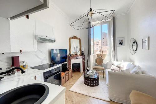 une cuisine et un salon avec un canapé et une table dans l'établissement Le Barocco - Calm - Hypercentre - Cosy, à Cannes