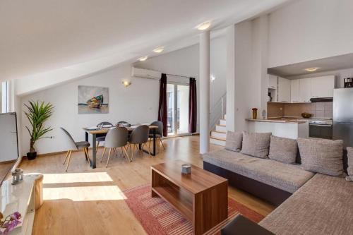 a living room with a couch and a table at Apartments Villa Mirela in Petrcane
