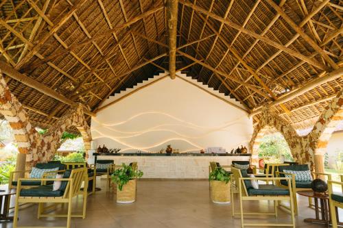 a restaurant with a large ceiling with chairs and tables at Palumbo Mnemba View Resort 