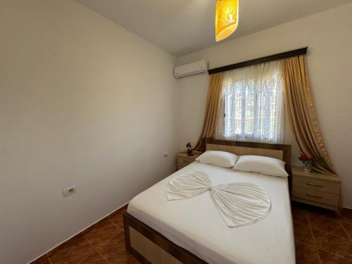 a bedroom with a bed with a bow on it at Villa Fjori Ksamil in Ksamil