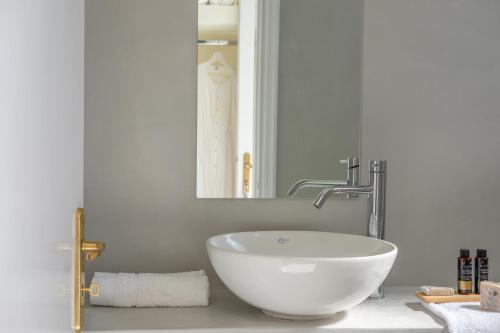 a bathroom with a bowl sink and a mirror at Oltremare Inn in Spetses