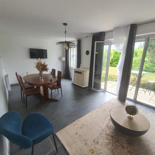 un salon avec une table et des chaises bleues dans l'établissement Jolie maison, à Gurgy