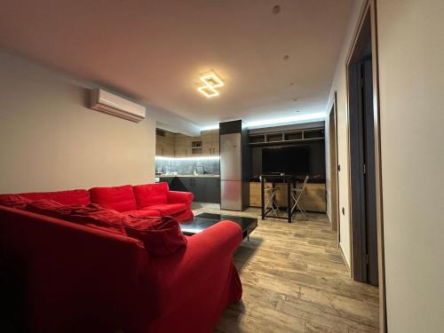 a living room with a red couch and a kitchen at Magic View Luxury Villa 4u - Spiro Spero in Kineta