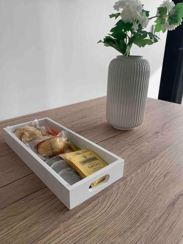 une boîte de nourriture posée sur une table avec un vase dans l'établissement Le Roof top Béthunois - Appart hôtel duplex centre - all confort, à Béthune