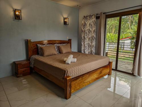 a bedroom with a bed with a teddy bear on it at AJ House & Suites in Uvita
