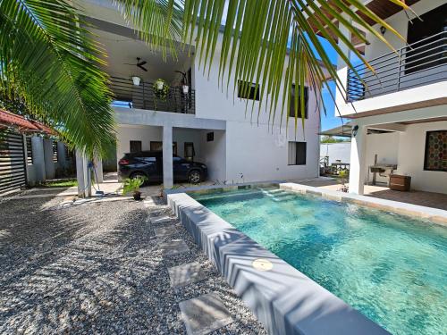 a swimming pool in front of a house at AJ House & Suites in Uvita