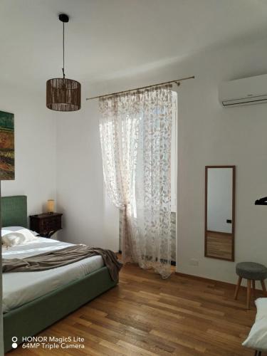 a bedroom with a bed and a window with a mirror at Kalìda Space - Camera matrimoniale in La Spezia
