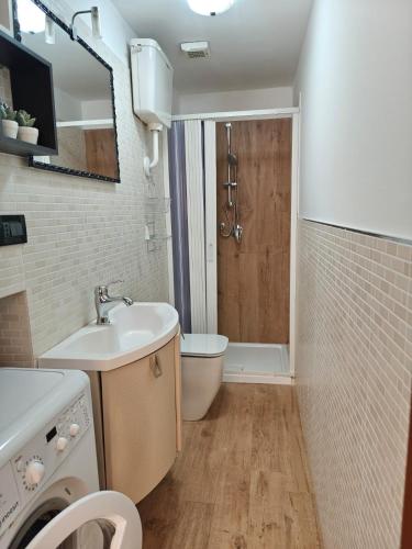 a bathroom with a sink and a washing machine at Kalìda Space - Camera matrimoniale in La Spezia