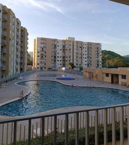 a large swimming pool with people in it with buildings at Aviva Sierra Tayrona Way in Santa Marta