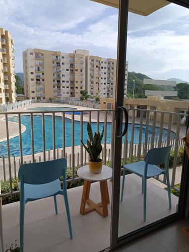 a balcony with two chairs and a table with a plant at Aviva Sierra Tayrona Way in Santa Marta