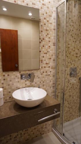 a bathroom with a sink and a glass shower at Blue Bay Hotel in Karpathos Town
