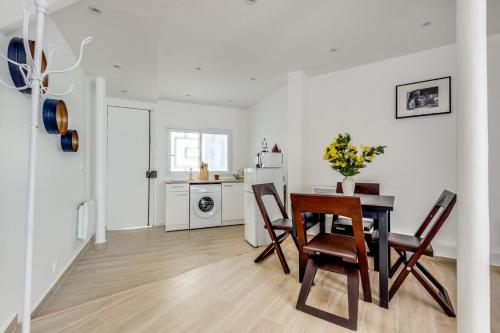 une cuisine et une salle à manger avec une table et des chaises dans l'établissement Le Saint Georges - Proche Pigalle, à Paris