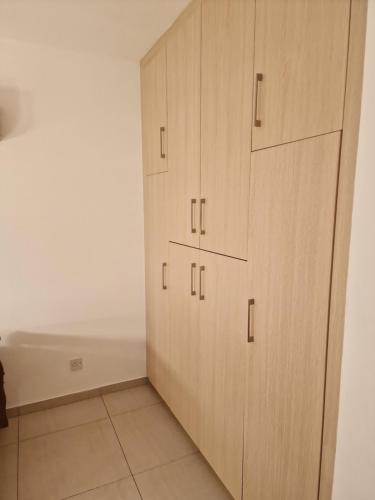 a closet with wooden cabinets in a room at Oceania Bay Village in Pyla