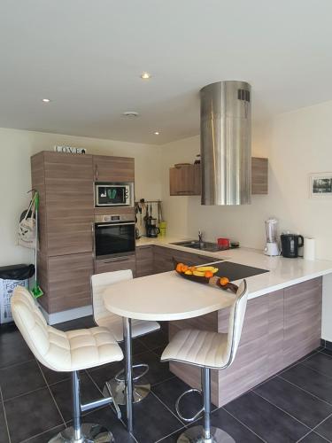 une cuisine avec une table et des chaises dans une cuisine dans l'établissement Paris sur une Ile, à Bougival