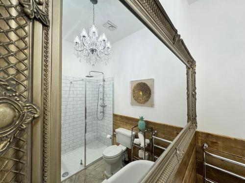 a bathroom with a toilet and a chandelier at The Bowl Inn in Charing