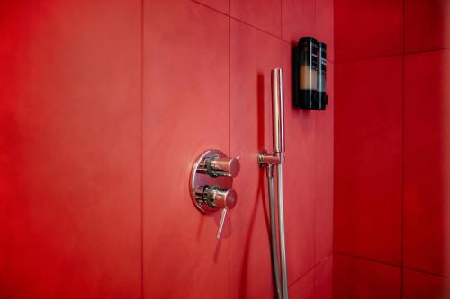 a red shower stall with a red wall at CefaLux - Apartments in Cefalù