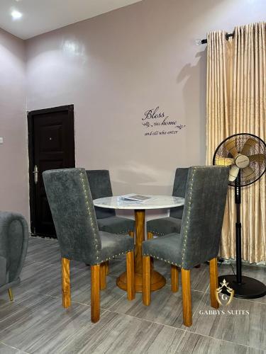 a table and four chairs in a room at Gabbys Suites in Abeokuta