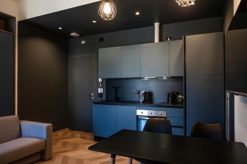 a kitchen with blue cabinets and a table at CefaLux - Apartments in Cefalù