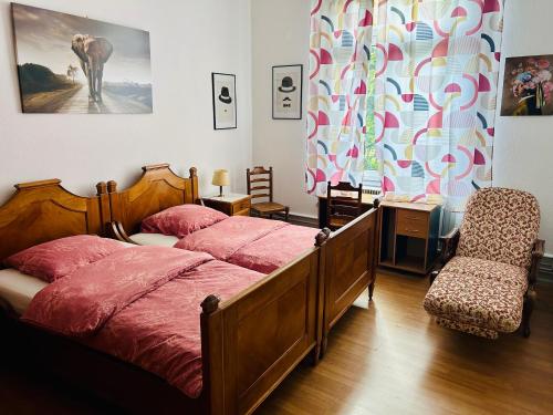 une chambre avec deux lits, un bureau et une chaise dans l'établissement appartement spacieux en centre ville, à Strasbourg