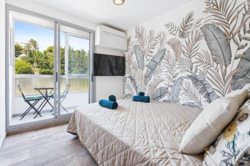 une chambre avec un lit et une grande fenêtre dans l'établissement Studio moderne avec Balcon - Plage et tramway a proximité, à Nice