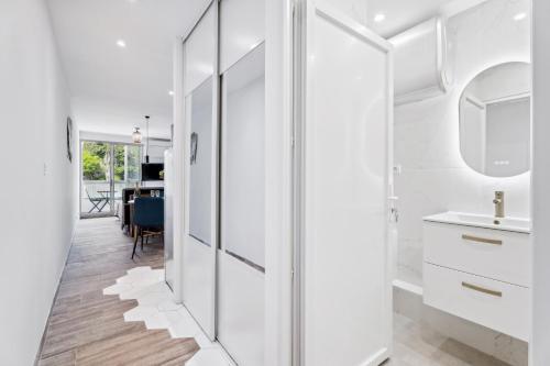 une salle de bain blanche avec un lavabo et un miroir dans l'établissement Studio moderne avec Balcon - Plage et tramway a proximité, à Nice