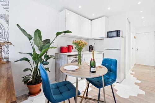 une petite cuisine avec une table et des chaises bleues dans l'établissement Studio moderne avec Balcon - Plage et tramway a proximité, à Nice